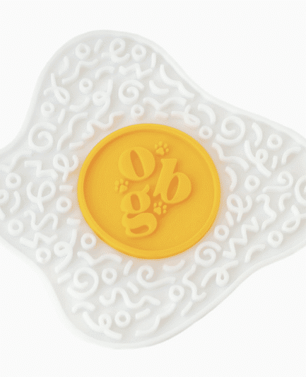 Tapis de léchage pour chien Ollie B. Good en forme d’œuf au plat, silicone alimentaire jaune et blanc.